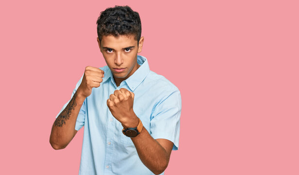 Young handsome african american man wearing casual clothes ready to fight with fist defense gesture, angry and upset face, afraid of problem
