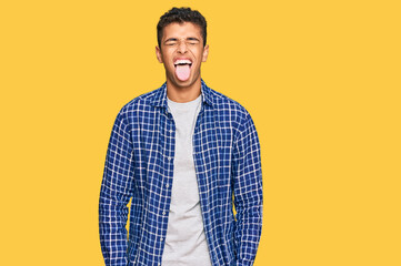 Young handsome african american man wearing casual clothes sticking tongue out happy with funny expression. emotion concept.