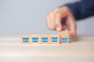 Franchise business,Businessman hand choose wooden blog with franchise marketing icons Store....