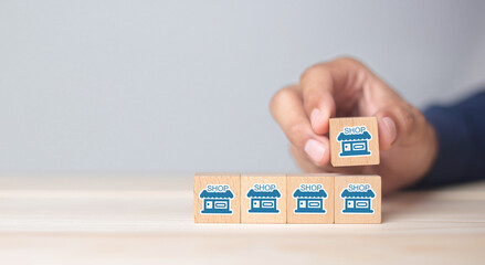 Franchise business,Businessman hand choose wooden blog with franchise marketing icons Store....