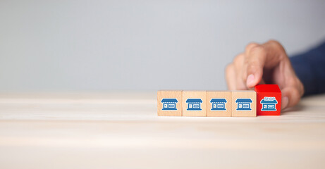 Franchise business,Businessman hand choose wooden blog with franchise marketing icons Store....