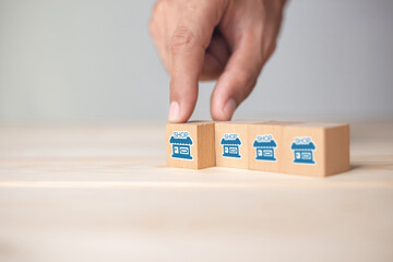 Franchise business,Businessman hand choose wooden blog with franchise marketing icons Store....