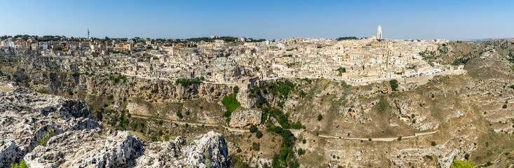 Fototapeta na wymiar Panoramic long view of Matera from Murgia Timone in a bright sunny day, Basilicata, Italy