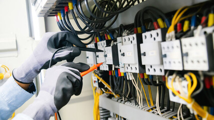 Electrical engineers test electrical installations and wiring on protective relays, measuring them...