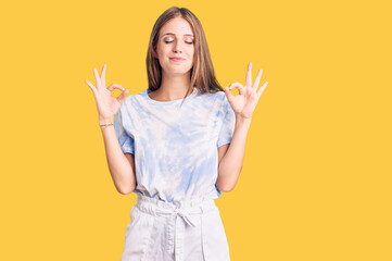 Young beautiful blonde woman wearing tye die tshirt relax and smiling with eyes closed doing meditation gesture with fingers. yoga concept.