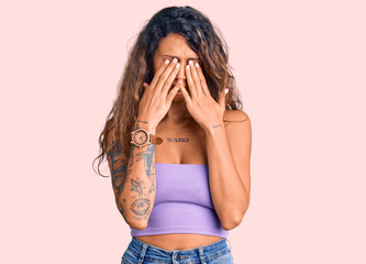 Young hispanic woman with tattoo wearing casual clothes rubbing eyes for fatigue and headache,...
