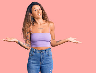 Young hispanic woman with tattoo wearing casual clothes smiling showing both hands open palms, presenting and advertising comparison and balance