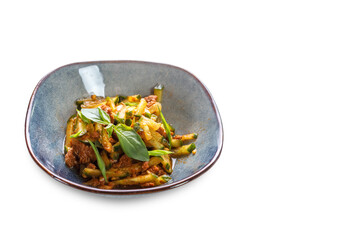A bowl with sliced cucumbers, meat in sauce and lettuce leaves on a white isolated background.
