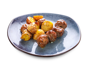 Fried potatoes in uniform and meat cutlets in a plate with greens on a white isolated background.