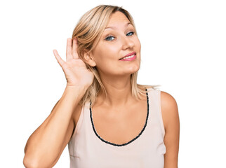 Fototapeta premium Middle age caucasian woman wearing casual clothes smiling with hand over ear listening an hearing to rumor or gossip. deafness concept.