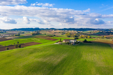 Aerial view of Monferrato countryside, Italian landscape with bright colors. Rural estate in the middle of green fields, scenic sky, copy space