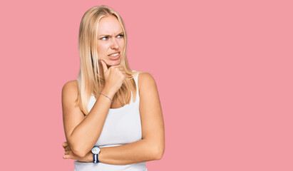 Young blonde girl wearing casual style with sleeveless shirt thinking worried about a question,...
