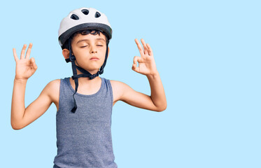 Little cute boy kid wearing bike helmet relax and smiling with eyes closed doing meditation gesture with fingers. yoga concept.