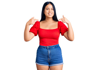 Young beautiful asian girl wearing casual clothes looking confident with smile on face, pointing oneself with fingers proud and happy.