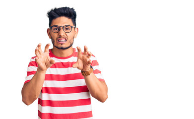 Fototapeta premium Handsome latin american young man wearing casual clothes and glasses smiling funny doing claw gesture as cat, aggressive and sexy expression