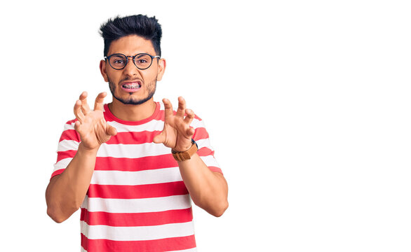 Handsome latin american young man wearing casual clothes and glasses smiling funny doing claw gesture as cat, aggressive and sexy expression