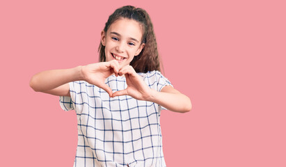 Cute hispanic child girl wearing casual clothes smiling in love doing heart symbol shape with hands. romantic concept.