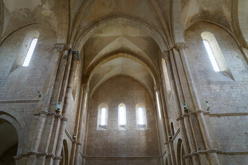 interno abbazia medioevale ,  veduta maestosa dal basso verso l'alto con volte restaurate , tre finestre sullo sfondo e due davanti 