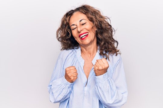 Middle Age Beautiful Brunette Woman Wearing Striped Shirt Standing Over White Background Celebrating Surprised And Amazed For Success With Arms Raised And Eyes Closed