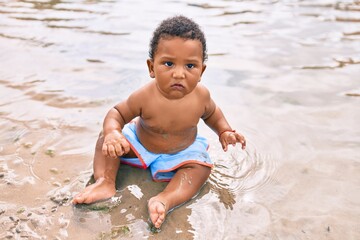 Adorable african american toddler sitting at the beach.