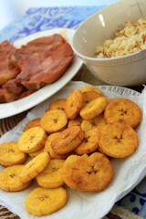 Rice with noodles, fried green plantains and fried pork chop.