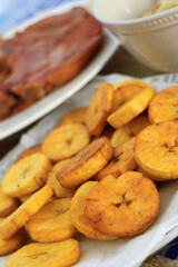 Tostones, patacones, fried green bananas, fried green platains, frito verde, with smoked pork chop.