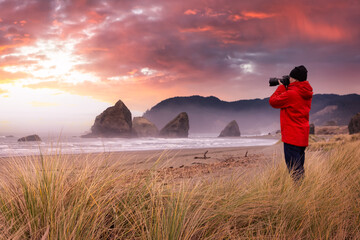 Photographer is taking pictures of the beautiful seaside view on the Oregon Coast. Colorful Sunset...