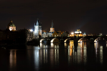 Obraz premium .Charles Bridge on the Vltava River and light from street lights in the center of Prague in winter