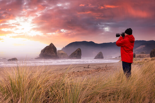 Photographer is taking pictures of the beautiful seaside view on the Oregon Coast. Colorful Sunset Sky Art Render.