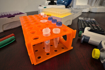 Silica column and eppendorf tube on a rack surrounded by laboratory materials; biochemistry and...