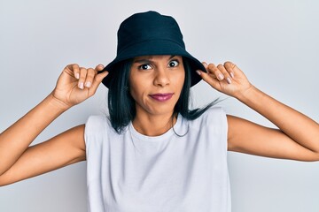 Young african american woman wearing fashion hat skeptic and nervous, frowning upset because of...