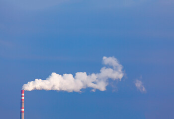 White smoke from industrial pipe at blue sky 