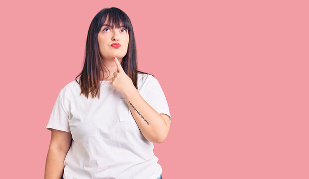 Young plus size woman wearing casual clothes thinking concentrated about doubt with finger on chin and looking up wondering