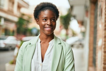 Fototapeta premium Young african american businesswoman smiling happy standing at the city