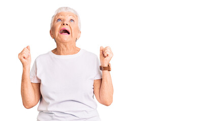 Senior beautiful woman with blue eyes and grey hair wearing casual white tshirt angry and mad screaming frustrated and furious, shouting with anger. rage and aggressive concept.