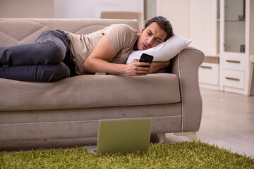 Young man lying on the sofa at home