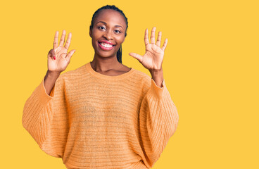 Young african american woman wearing casual clothes showing and pointing up with fingers number...