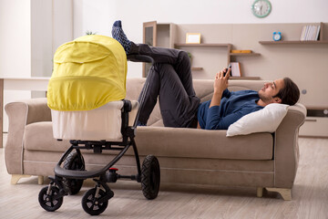 Young male contractor looking after baby at home