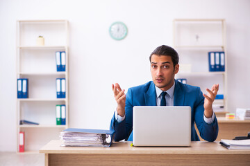 Young male employee and too many work in the office