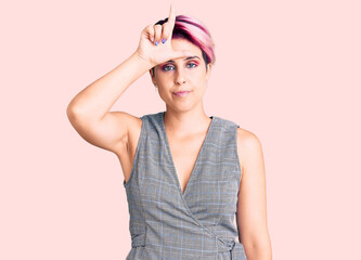 Young beautiful woman with pink hair wearing casual clothes making fun of people with fingers on...