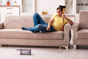 Fototapeta premium Young man and mousetrap at home