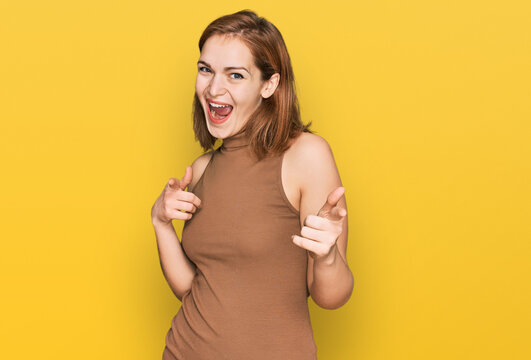 Young caucasian woman wearing casual clothes pointing fingers to camera with happy and funny face. good energy and vibes.