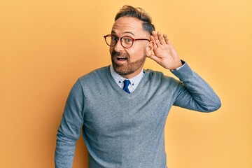 Handsome middle age man wearing glasses smiling with hand over ear listening and hearing to rumor...