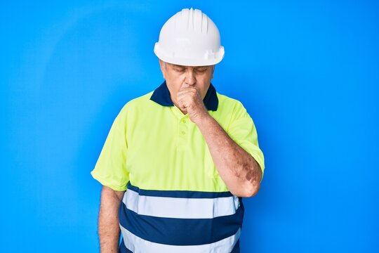 Senior grey-haired man wearing worker reflective t shirt and hardhat feeling unwell and coughing as symptom for cold or bronchitis. health care concept.