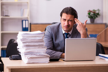 Young male employee unhappy with excessive work in the office