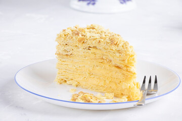 Napoleon Cake on a white plate. Traditional French dessert. Cake Napaleon of puff pastry on white background