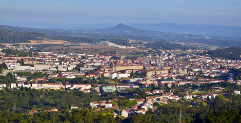 Fototapeta na wymiar Santiago de Compostela city landscape. Aerial view with houses and buildings in the foreground. Sky and mountains in the background.