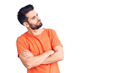 Obraz premium Young handsome man with beard wearing casual t-shirt looking to the side with arms crossed convinced and confident