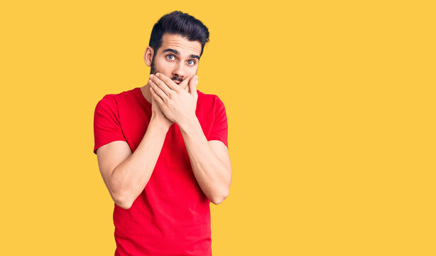 Young handsome man with beard wearing casual t-shirt shocked covering mouth with hands for mistake. secret concept.