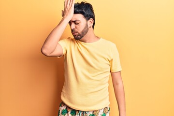 Young hispanic man wearing swimwear surprised with hand on head for mistake, remember error....